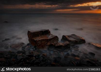 Long exposure dramatic sunset landscape with the rocky coast of Black sea