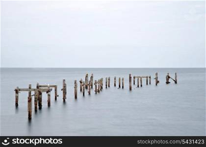 Long exposure image of derelict pier standings in calm smooth ocean