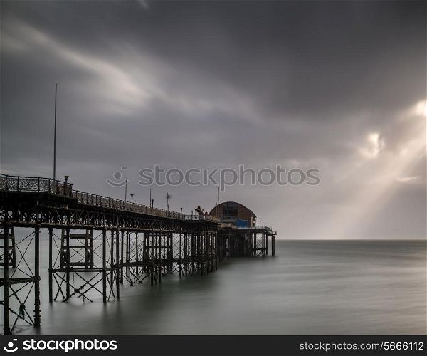 Long exposure landscape image of old pier stretching out to sea
