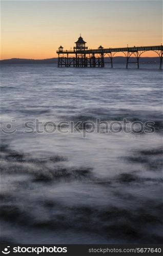 Long exposure landscape image of pier at sunset