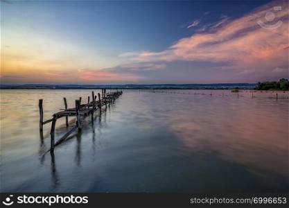 Long exposure landscape with old broken pier with reflection