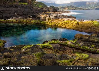 Long exposure of the calm waters of Queen&rsquo;s Bath, a rock pool off Princeville on north shore of Kauai. Long exposure image of the pool known as Queens Bath on north shore of Kauai
