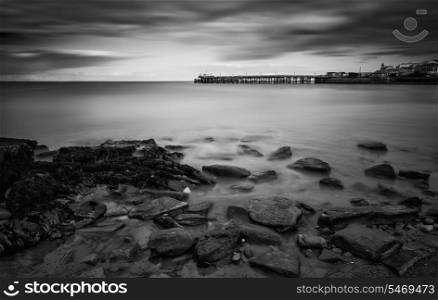 Long exposure seascape landscape during dramatic evening sunset in black and white