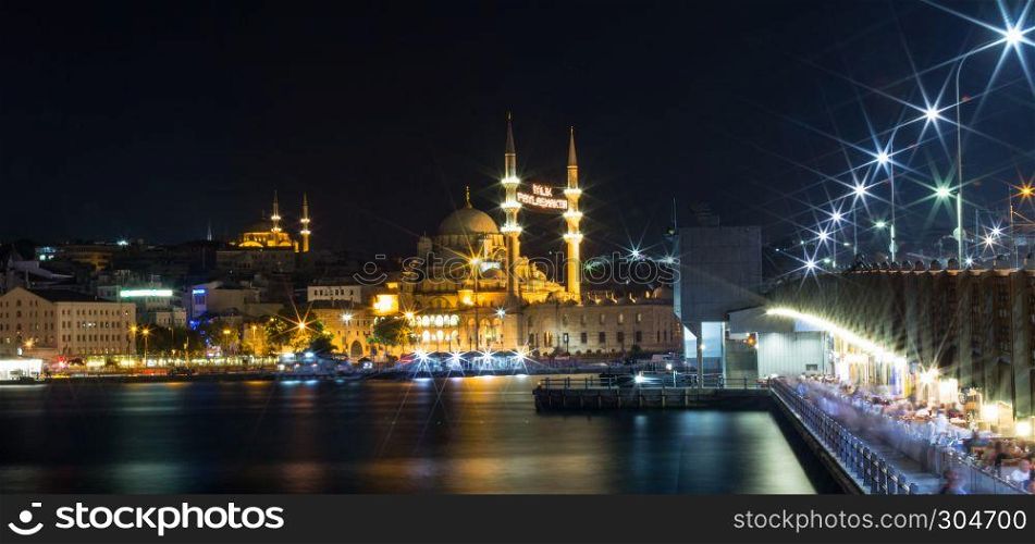 Long exposure shot of Yeni(New) Mosque,Eminonu and Galata Bridge with light trails after in Istanbul,Turkey.08 July 2015. Long exposure shot of Yeni(New) Mosque,Eminonu and Galata Bridge