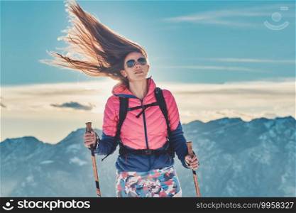 Long hair of a girl blown up by the strong wind during a mountain hike