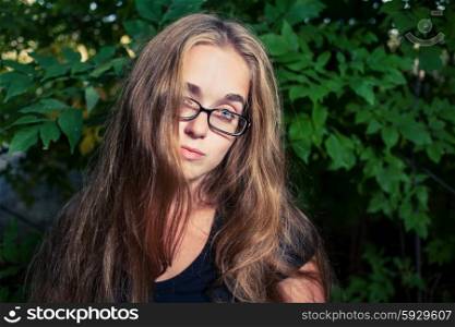 Long haired blonde posing in loneliness outdoors against nature background