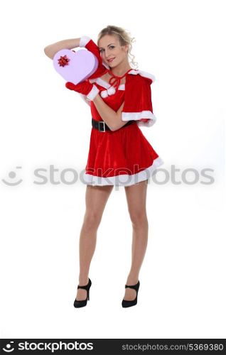 Long legged blonde in short Santa dress and heart shaped gift