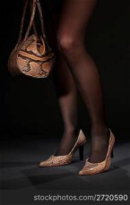 long legs in snakeskin shoes with handbag