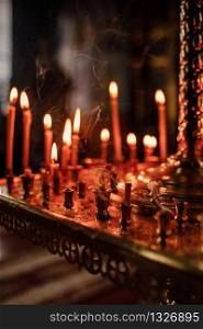 long lighted candles group in orthodox church. candles background. selective focus.. long lighted candles group in orthodox church. candles background. selective focus