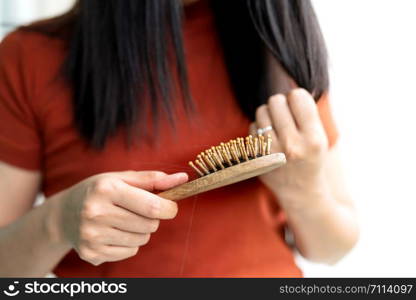 long loss hair fall on woman brush with and woman looking at her hair
