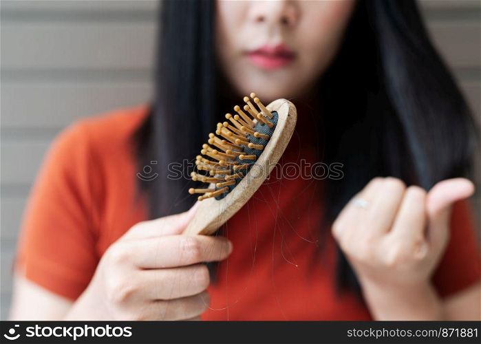 long loss hair on woman brush with and woman looking at her hair