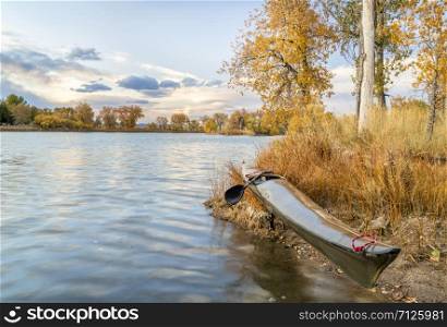 long, narrow and fast racing sea kayak on shore of calm lake, fall scenery in Colorado