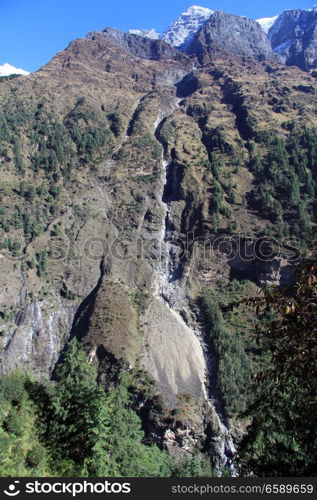 Long narrow waterfall in mountain in Nepal