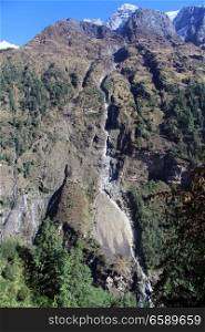 Long narrow waterfall in mountain in Nepal