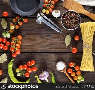 long pasta raw tied up with rope and ingredients for cooking food on a brown wooden table, close up