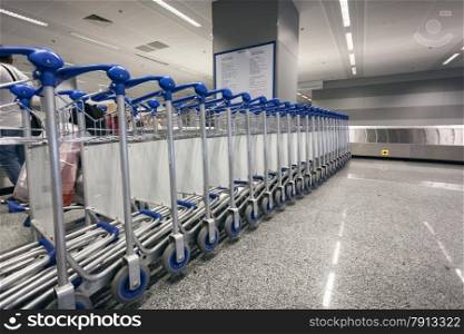 Long row of luggage trolleys at airport terminal