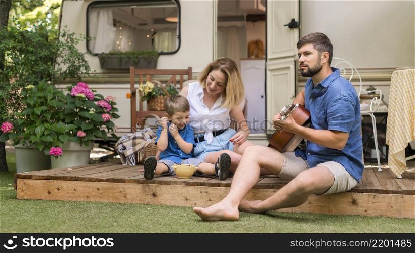 long shot family enjoying some guitar music