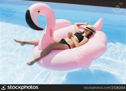 long shot girl laying down flamingo floatie