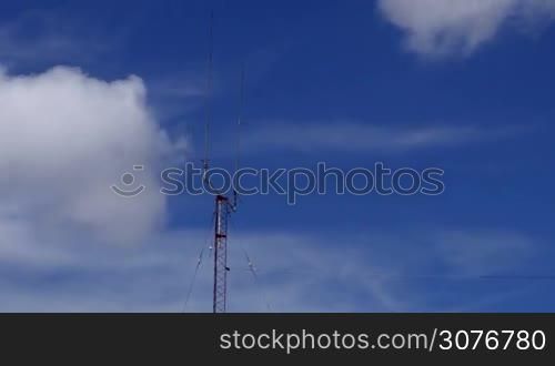 Long shot of a Home based dual spike Telecommunications antenna tower with clouds clearing the sky time lapse with no birds in it.