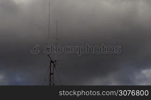 Long shot of a Home based dual spike Telecommunications antenna tower with storm clouds time lapse with no birds in it.