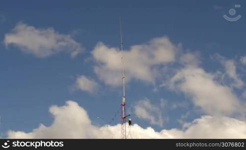 Long shot of a Home based single spike Telecommunications antenna tower heavy clouds day time lapse with no birds in it.
