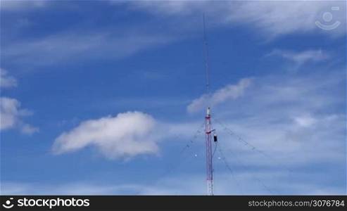 Long shot of a Home based single spike Telecommunications antenna tower light clouds day time lapse with no birds in it.