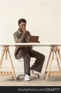 long shot person sitting working laptop
