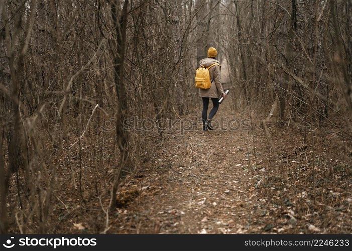 long shot woman hiking with flask