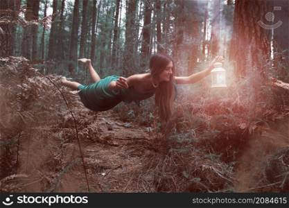 long shot woman levitating forest with lantern