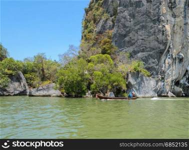 Long-tailed boat and limestone karsts of Phang Nga Bay National Park in Phang Nga Province, Thailand