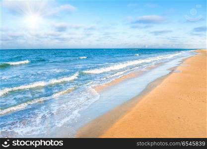 Long tropical sandy beach with surf and sea waves. Long tropical sandy beach