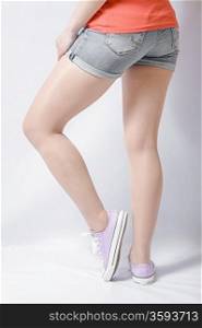 Long woman legs on white pink gumshoes on side view