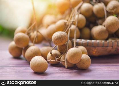Longan on basket / Dimocarpus longan fruit on wooden background and sunlight in summer