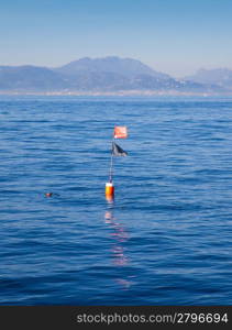 Longliner and trammel net buoy with flag pole in blue sea