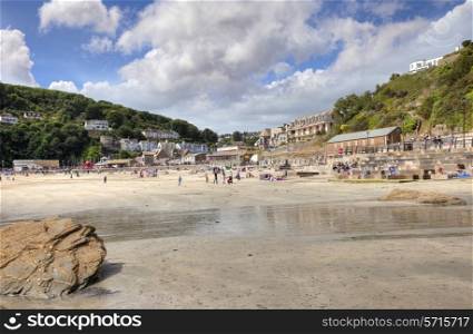 Looe, Cornwall, UK ? August 24, 2013: People enjoying the sun on the popular holiday destination of East Looe Beach.
