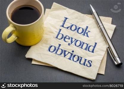 look beyond obvious - creativity and motivation reminder - handwriting on a napkin with a cup of coffee