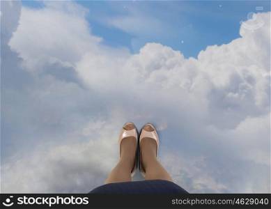 Look from top. Top view of businesswoman feet standing on clouds