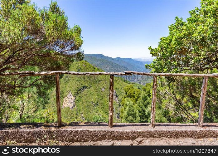Look through wooden fence with abyss, valley and mountainds in Portugal