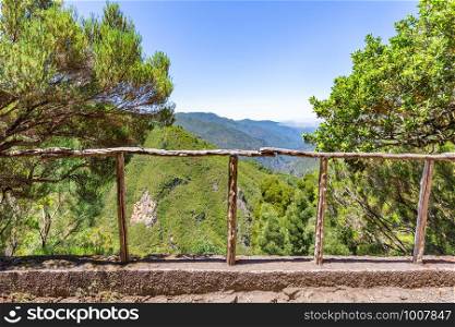 Look through wooden fence with abyss, valley and mountainds in Portugal