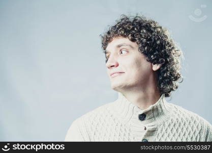 Looking away. Portrait of a young caucasian guy with curly hair
