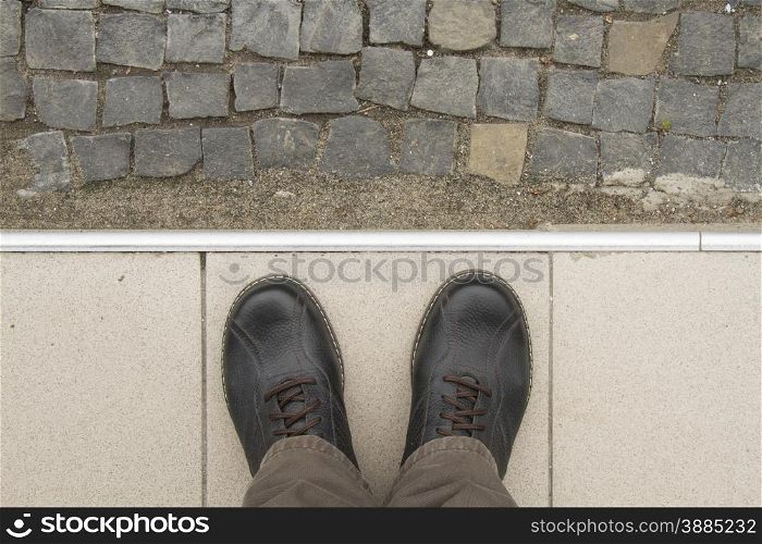 Looking down man feet on cobbled road