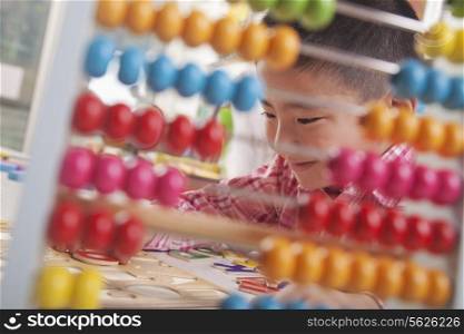 Looking Through Abacus at Boy Solving a Puzzle