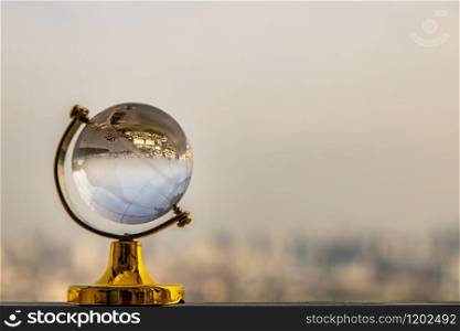 Looking through crystal globe showing an upside down skyline. Refraction photography. Selective focus
