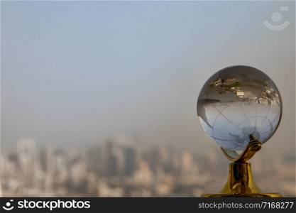 Looking through crystal globe showing an upside down skyline. Refraction photography. Selective focus, copy space
