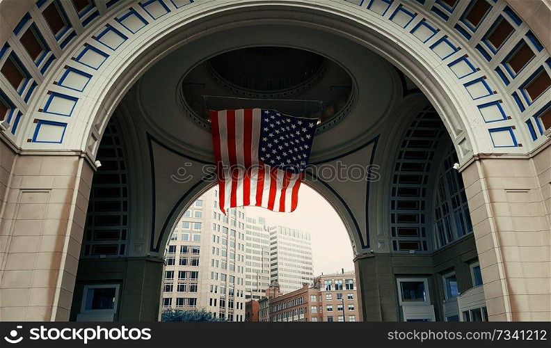 Looking through the arch at Rowes Wharf, in Boston, Massachusetts. USA flag hoisted