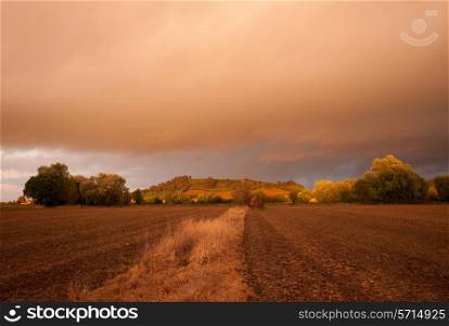 Looking towards Meon Hill over farmland with a dramatic sunset, Gloucestershire, England.