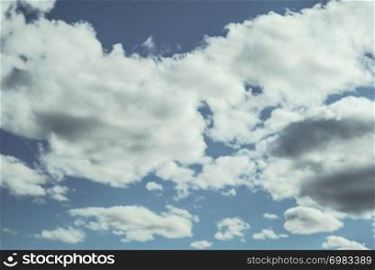 Looking up at a blue overcast summer sky with fluffy, soft white clouds - Concept of daydreaming, weather or meteorology.. Looking up at a blue overcast summer sky with fluffy, soft white clouds - Concept of daydreaming, weather or meteorology