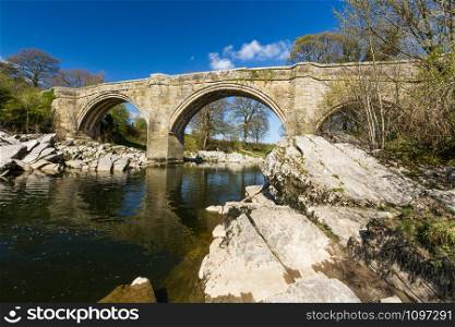Looking up at Devils Bridge, over the River Lune. Kirkby Lonsdale, Cumbria, England, landscape, wide angle.