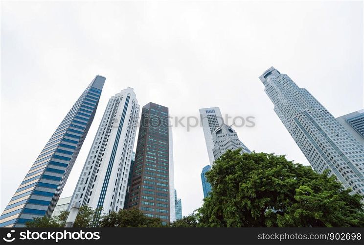 Looking up to high-rise office buildings, skyscrapers, architectures in financial district. Smart urban city for business and technology concept background in Downtown Singapore.