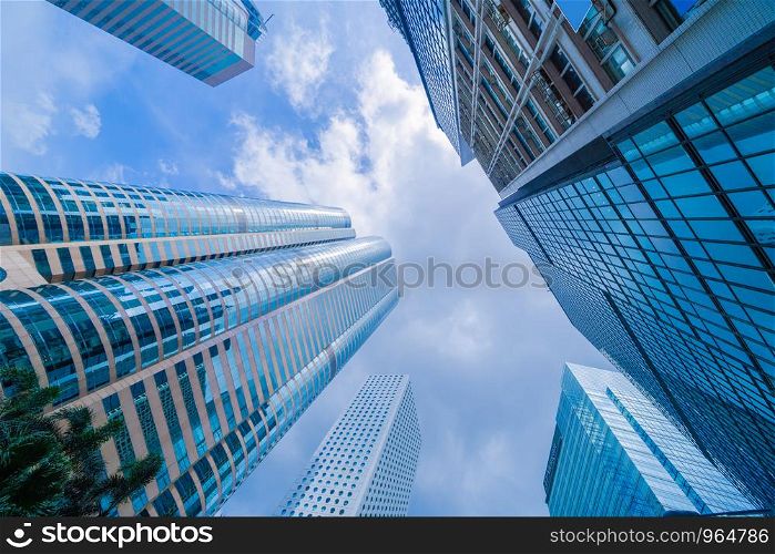 Looking up to high-rise office buildings, skyscrapers, architectures in financial district. Smart urban city for business and technology concept background in Downtown Hong Kong, China.
